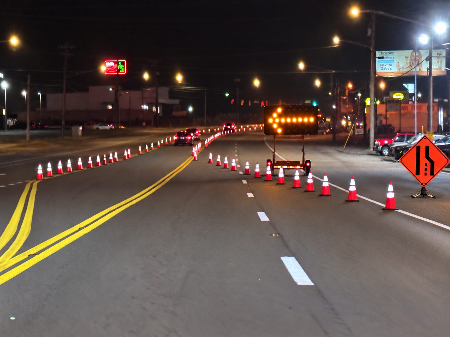 Night lane closure on Gallatin Pike in Madison, TN with a lane-reduction sign, lit arrow board and channelizing cones