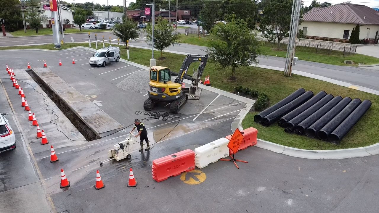 Aerial view of a cone line, water-filled barriers and a Utility Work Ahead sign around a drive-thru trench at a McDonald's in Shelbyville, TN
